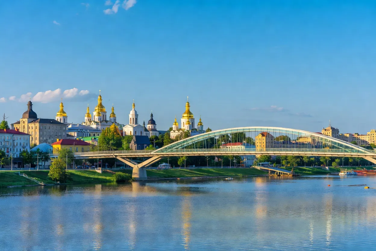 Pont piétonnier moderne enjambant le Dniepr à Kyiv avec les dômes dorés en arrière-plan