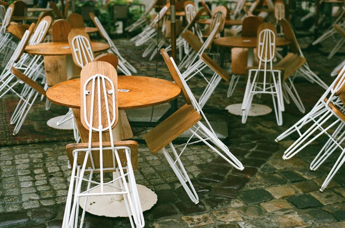 Terrasse de caf&eacute; sur une rue pav&eacute;e de Lviv avec tables en bois