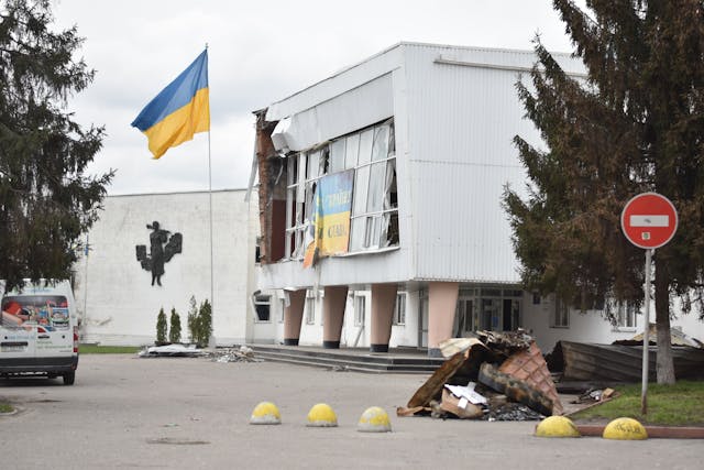 Drapeau ukrainien devant un bâtiment endommagé par la guerre